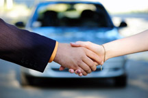 Shaking hands in front of car